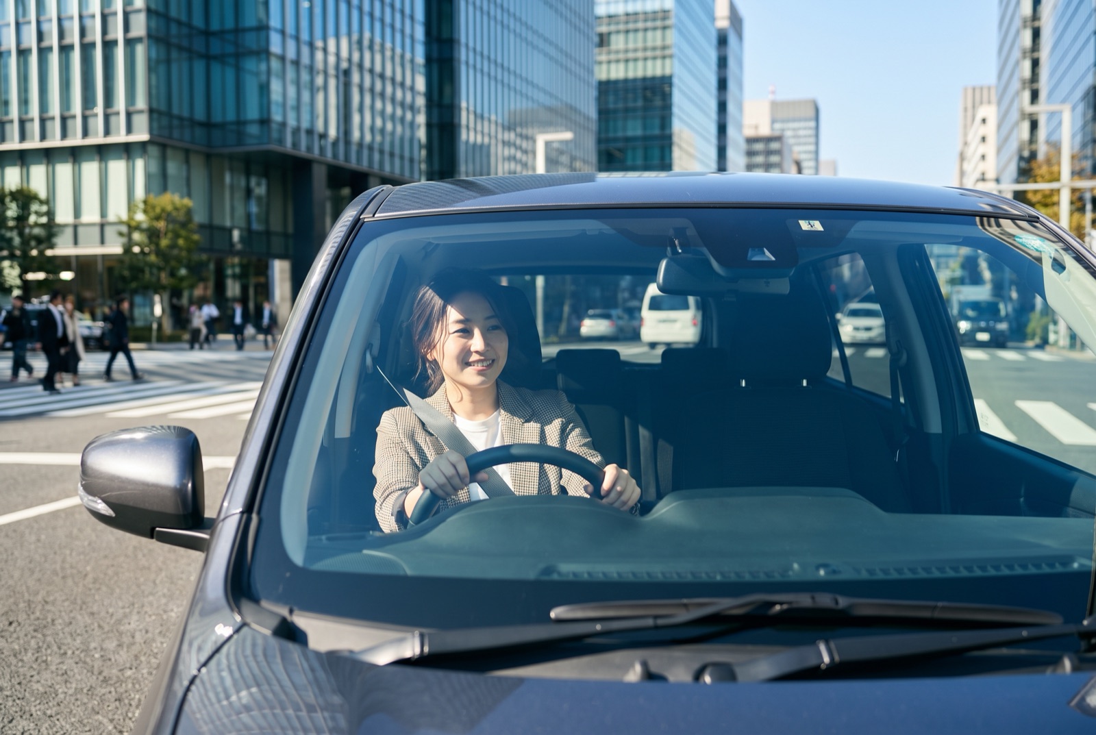 コンパクトカーの運転席に座る20代の女性