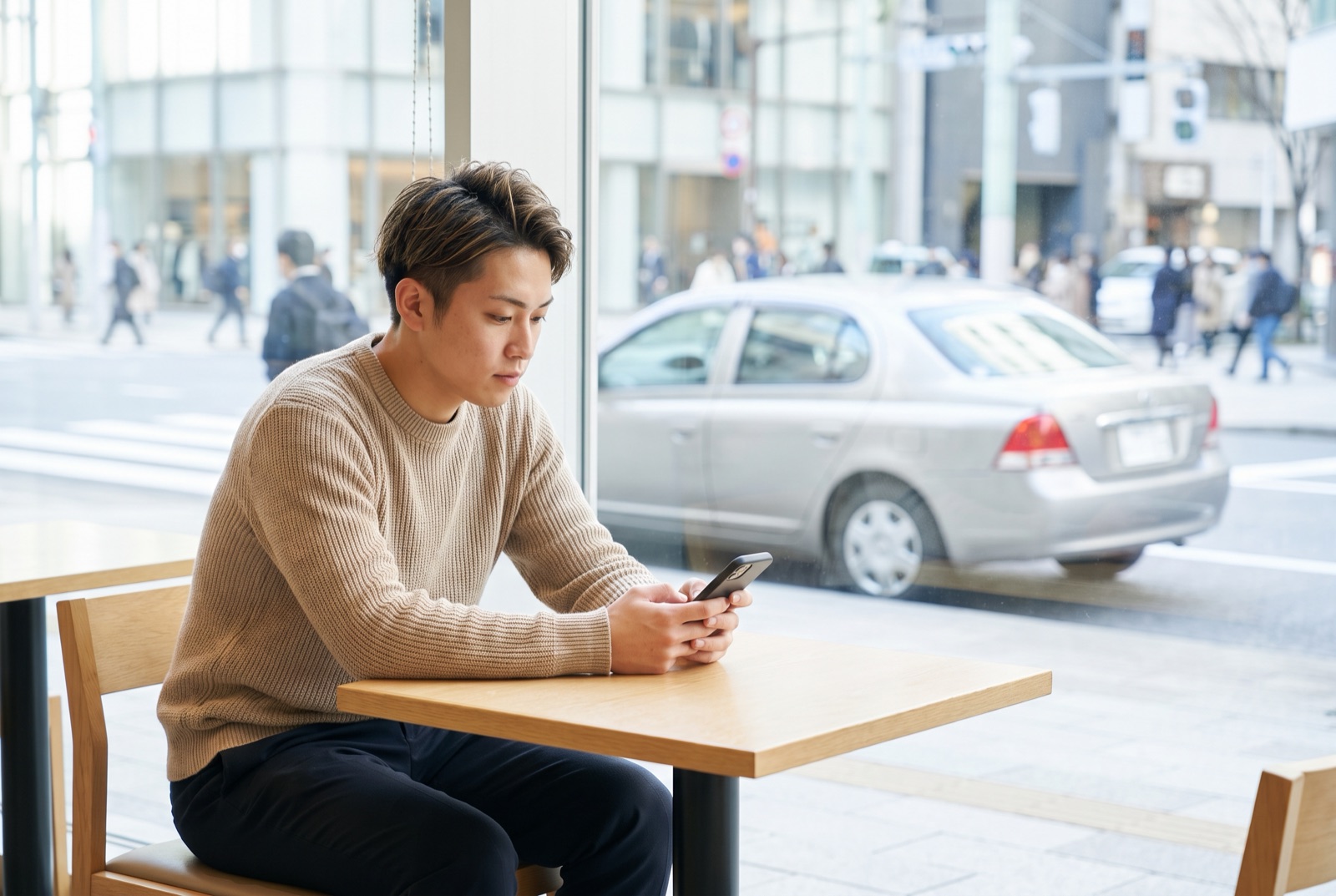 スマートフォンで保険の見積もりを比較する若い男性