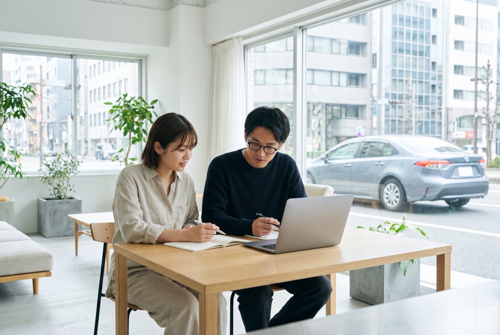 自宅で車の予算を相談する若い夫婦