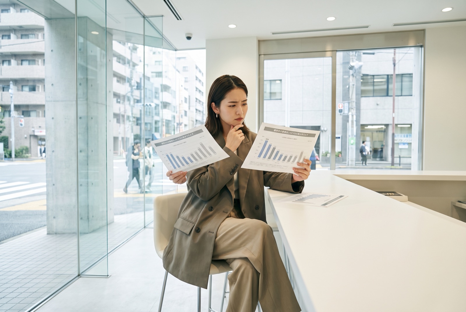 2枚の見積書を見比べる女性