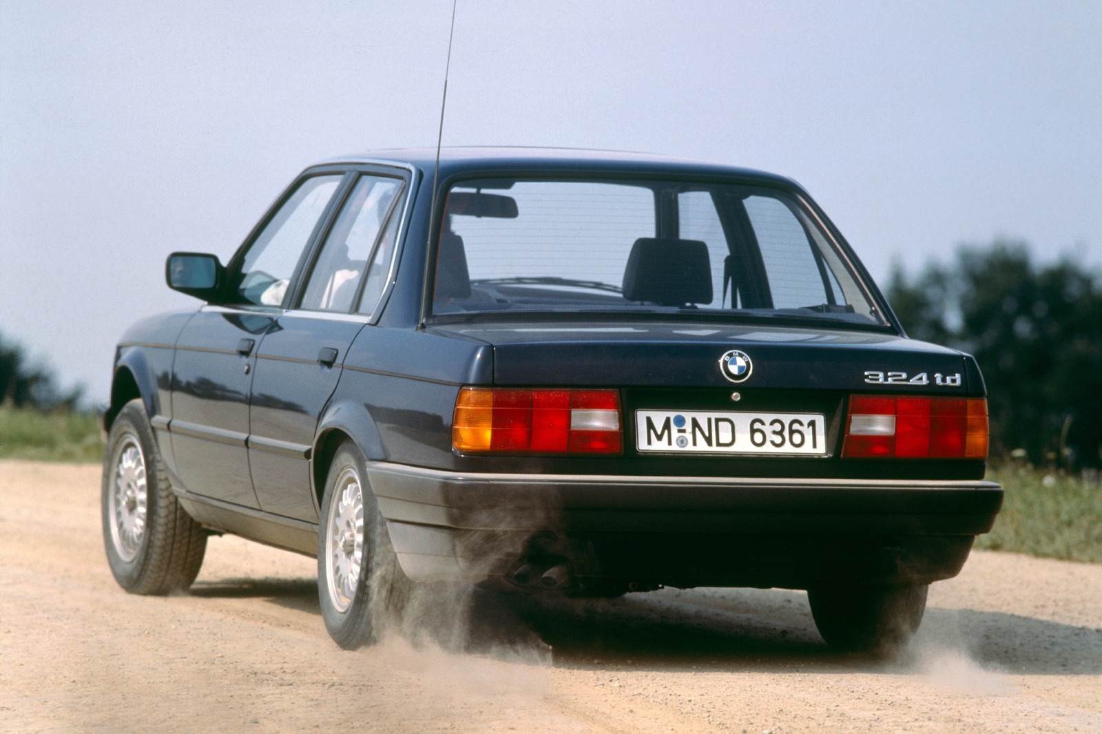 未舗装路を走る白いBMW E30